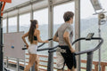 Man and woman running on treadmills in an open-air mountain view gym, keto fitness workout for SiBio ketone monitor users