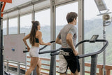 Man and woman running on treadmills in an open-air mountain view gym, keto fitness workout for SiBio ketone monitor users