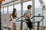 Man and woman running on treadmills in an open-air mountain view gym, keto fitness workout for SiBio ketone monitor users